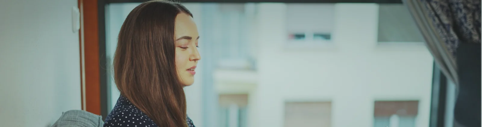 Person looking thoughtfully towards a bright window